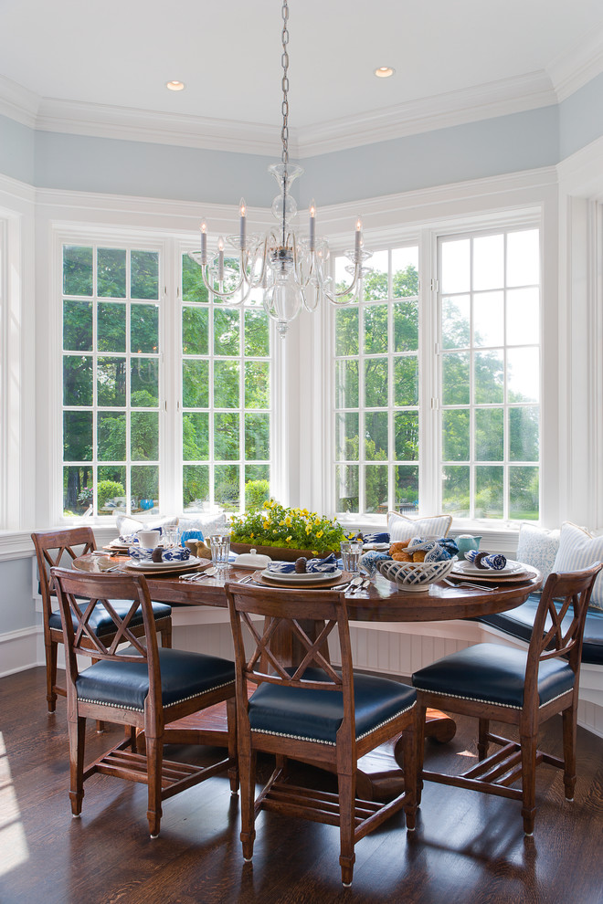 This is an example of a traditional dining room in New York with blue walls and dark hardwood flooring.