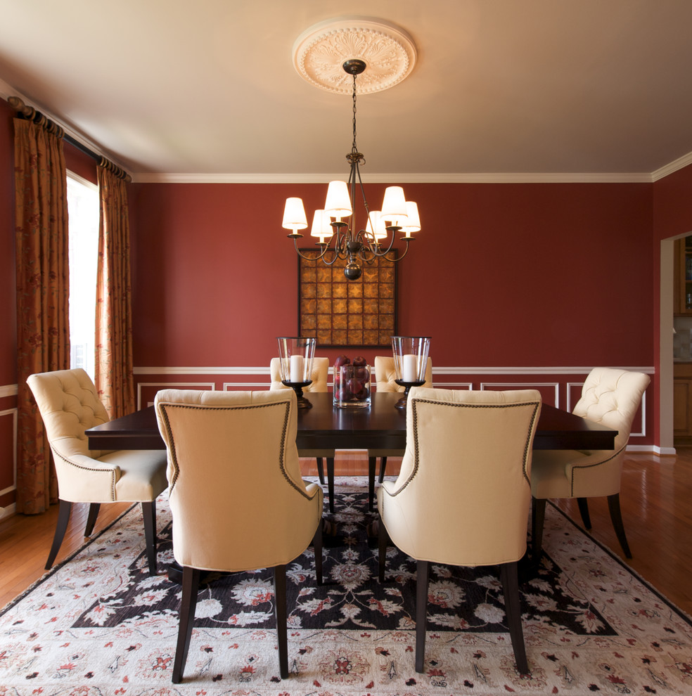 Example of a classic dark wood floor dining room design in DC Metro with red walls