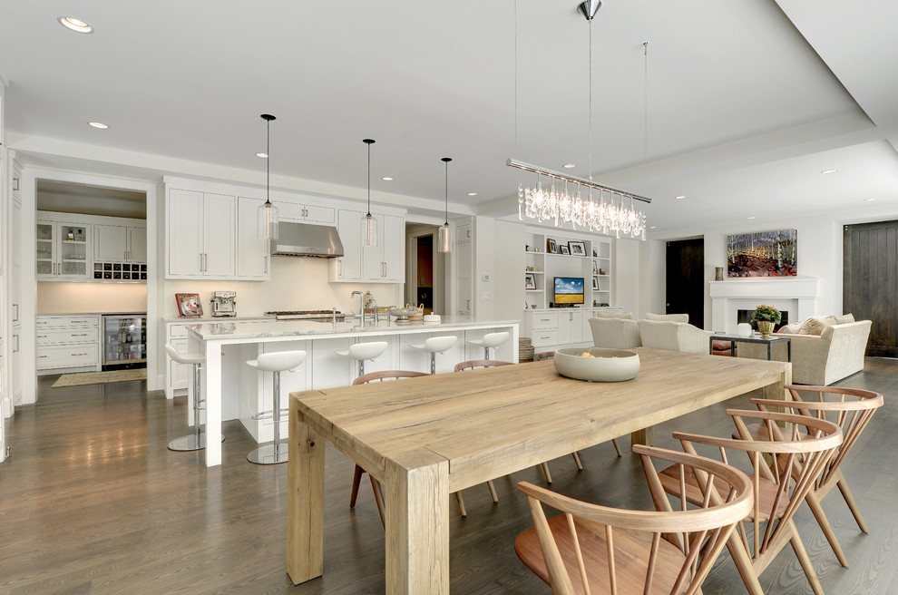Immagine di una sala da pranzo aperta verso la cucina chic con pareti bianche e pavimento in legno massello medio
