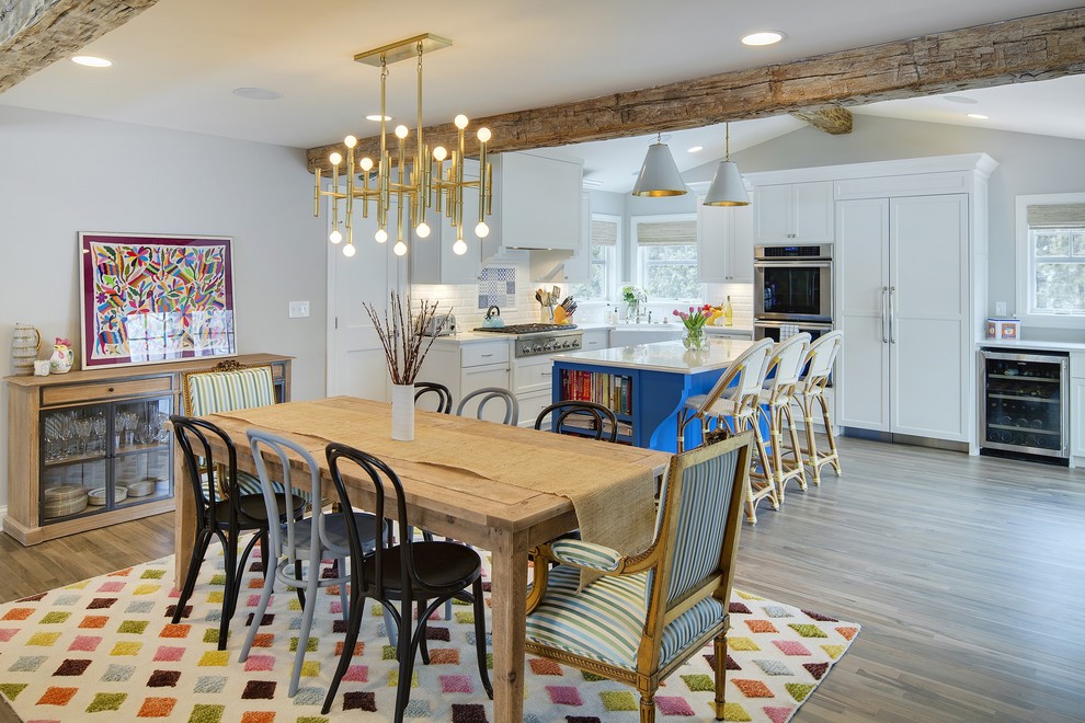 Cette photo montre une salle à manger ouverte sur la cuisine tendance de taille moyenne avec un mur gris, parquet clair, aucune cheminée et un sol marron.