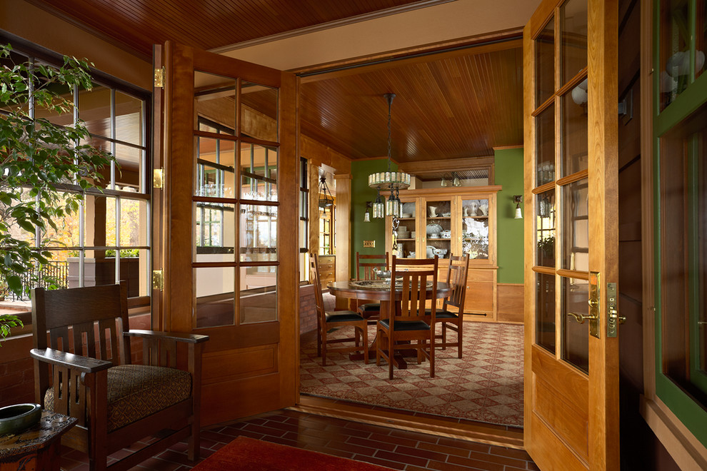 Cette photo montre une salle à manger craftsman fermée avec un mur vert et aucune cheminée.
