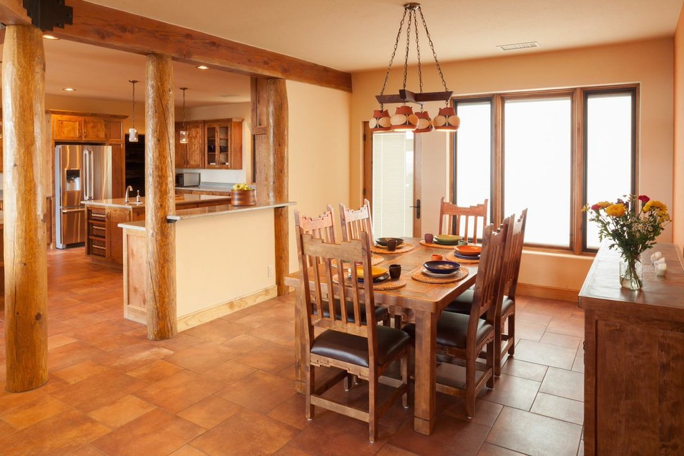 Foto di una grande sala da pranzo aperta verso la cucina stile americano con pareti beige, pavimento in terracotta, nessun camino e pavimento beige
