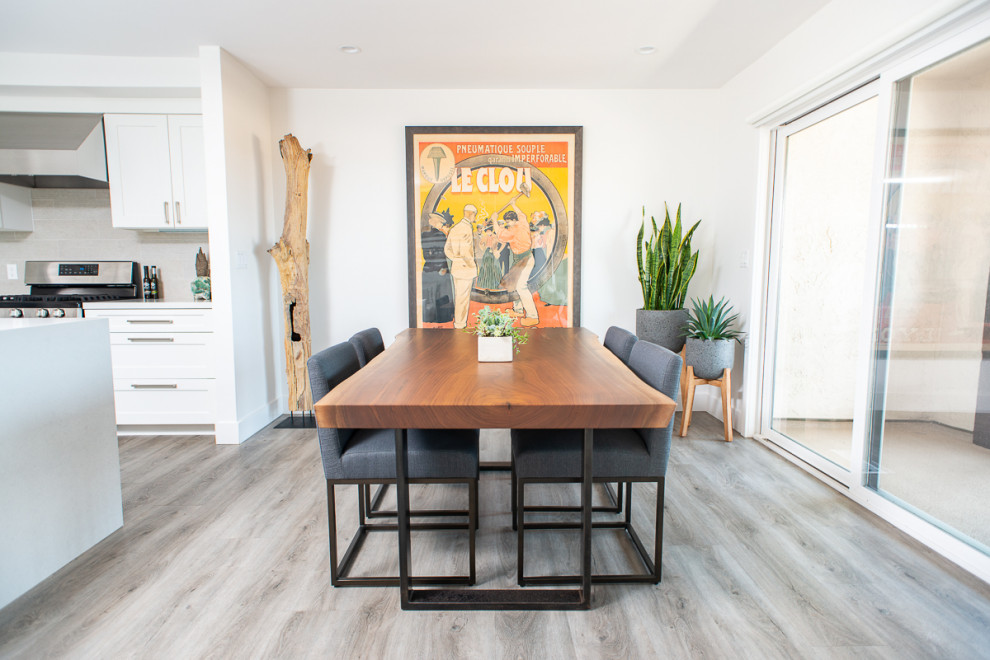 Immagine di una sala da pranzo aperta verso la cucina moderna di medie dimensioni con pareti bianche, pavimento in vinile e pavimento grigio