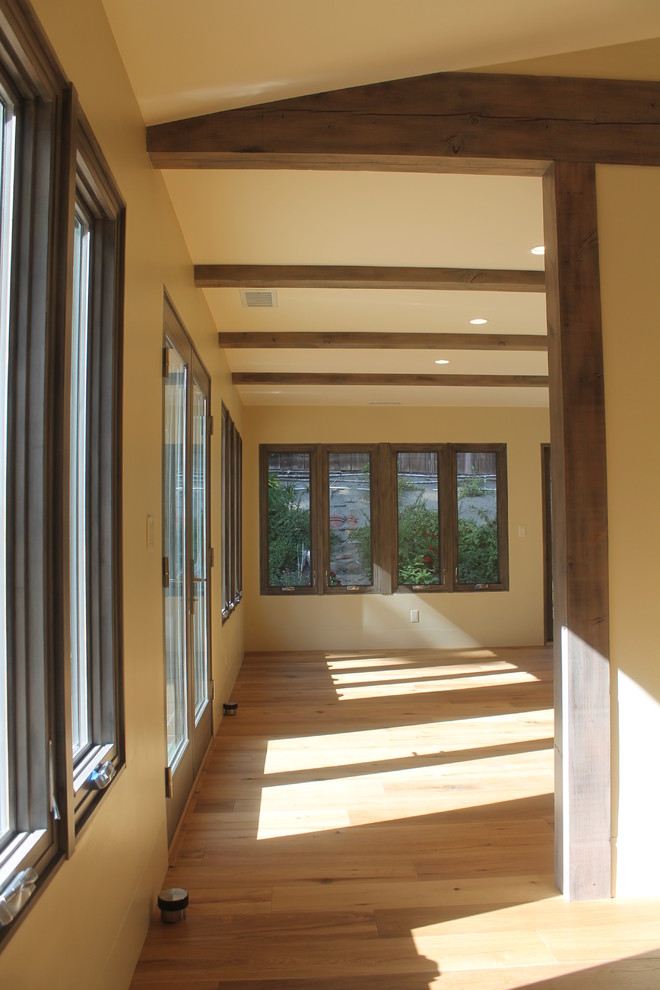 Cette image montre une salle à manger ouverte sur la cuisine design de taille moyenne avec un mur beige, aucune cheminée et un sol en bois brun.
