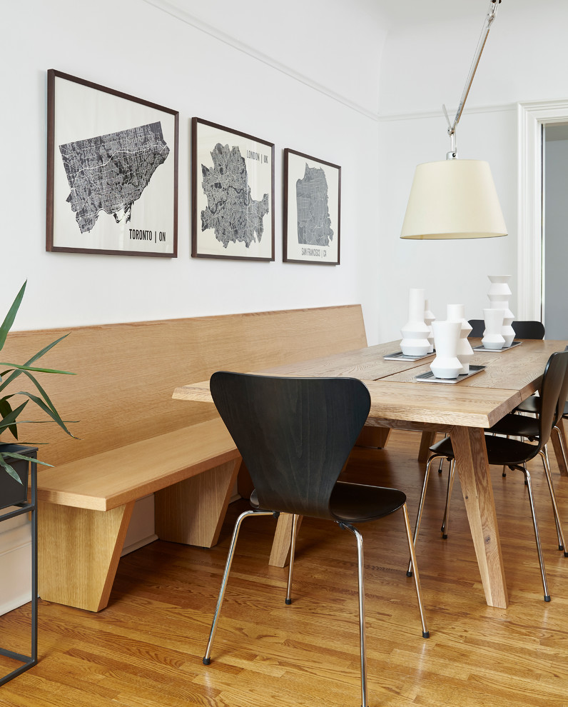 This is an example of a medium sized scandi enclosed dining room in Toronto with white walls, light hardwood flooring, no fireplace, beige floors and feature lighting.