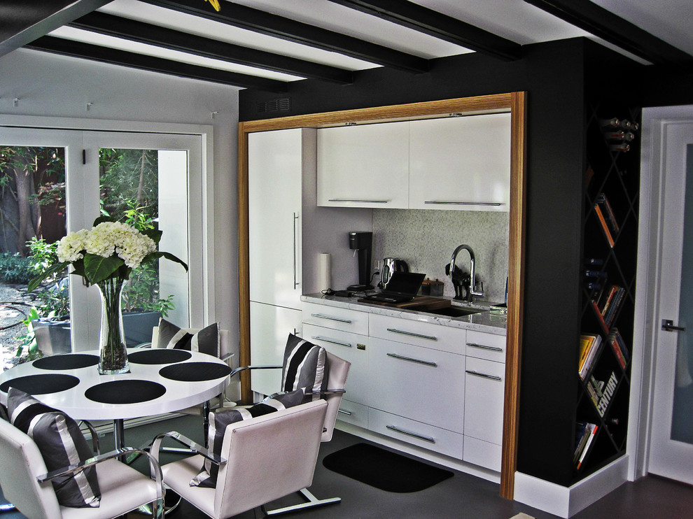 Foto di una sala da pranzo aperta verso la cucina moderna di medie dimensioni con pareti grigie e pavimento in laminato
