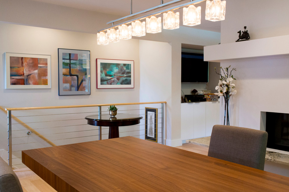 На фото: кухня-столовая среднего размера в стиле модернизм с светлым паркетным полом и двусторонним камином