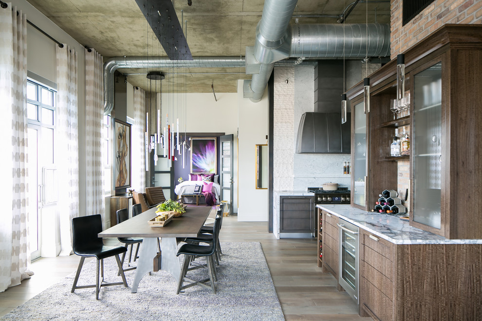 Immagine di una sala da pranzo aperta verso la cucina industriale di medie dimensioni con pareti bianche, pavimento in legno massello medio e pavimento grigio