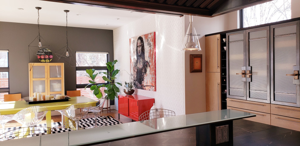 Cette image montre une grande salle à manger ouverte sur la cuisine minimaliste avec un mur blanc, un sol en bois brun, une cheminée standard, un manteau de cheminée en brique et un sol marron.