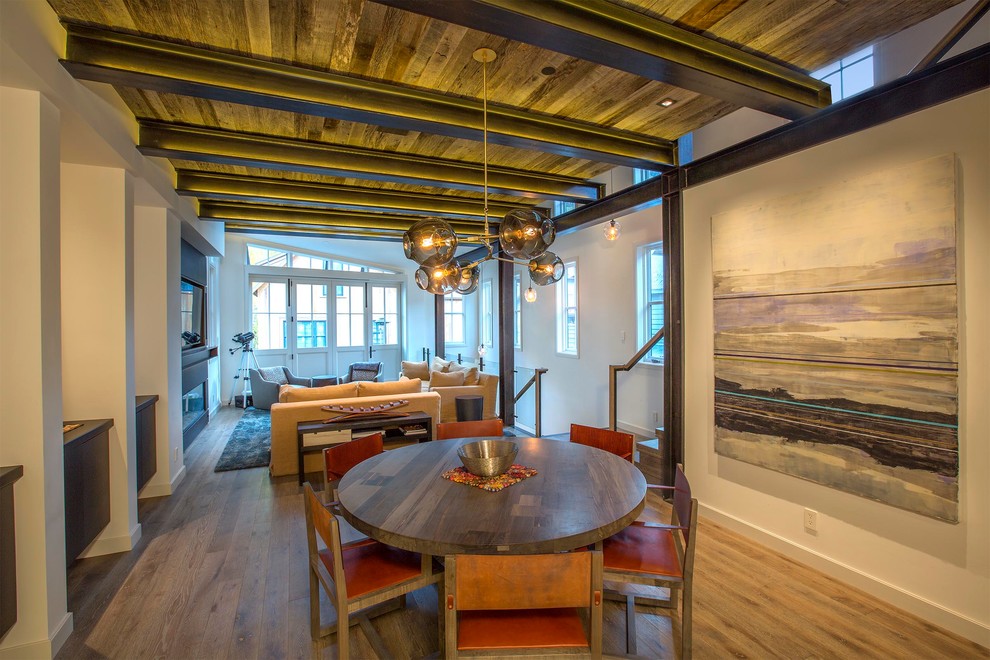 Foto di una sala da pranzo aperta verso la cucina rustica di medie dimensioni con pareti bianche e parquet chiaro