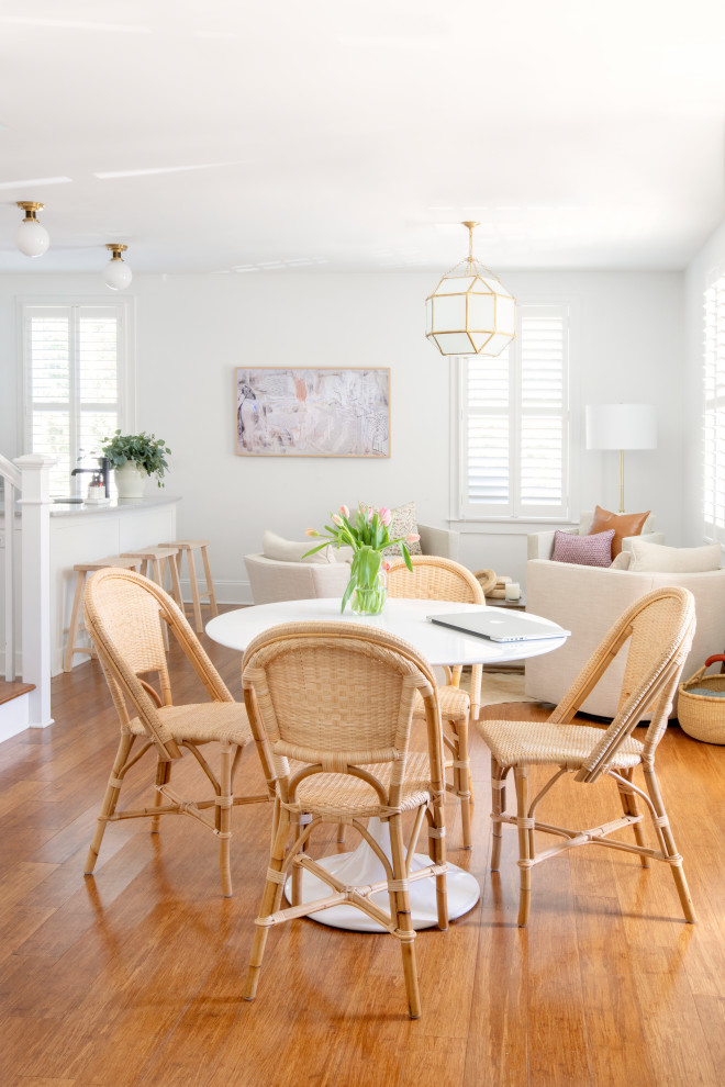 Cette image montre une salle à manger ouverte sur le salon traditionnelle de taille moyenne avec un mur blanc, un sol en bois brun et un sol marron.
