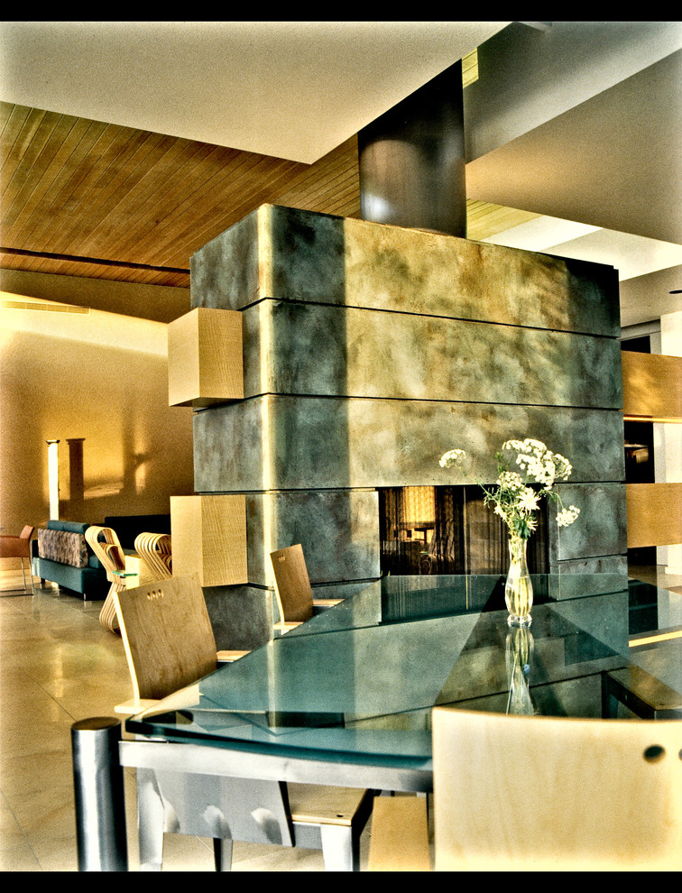 Идея дизайна: большая гостиная-столовая в современном стиле с коричневыми стенами, полом из известняка, стандартным камином и фасадом камина из металла