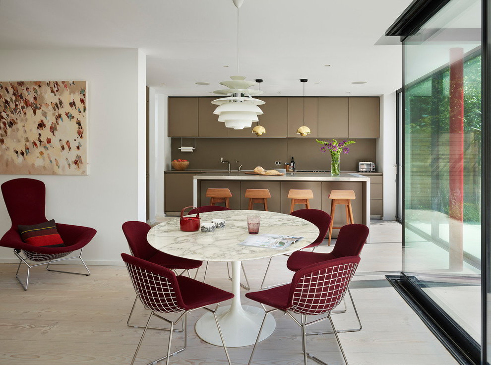 Inspiration pour une salle à manger ouverte sur le salon design de taille moyenne avec un mur blanc, parquet clair et un sol beige.
