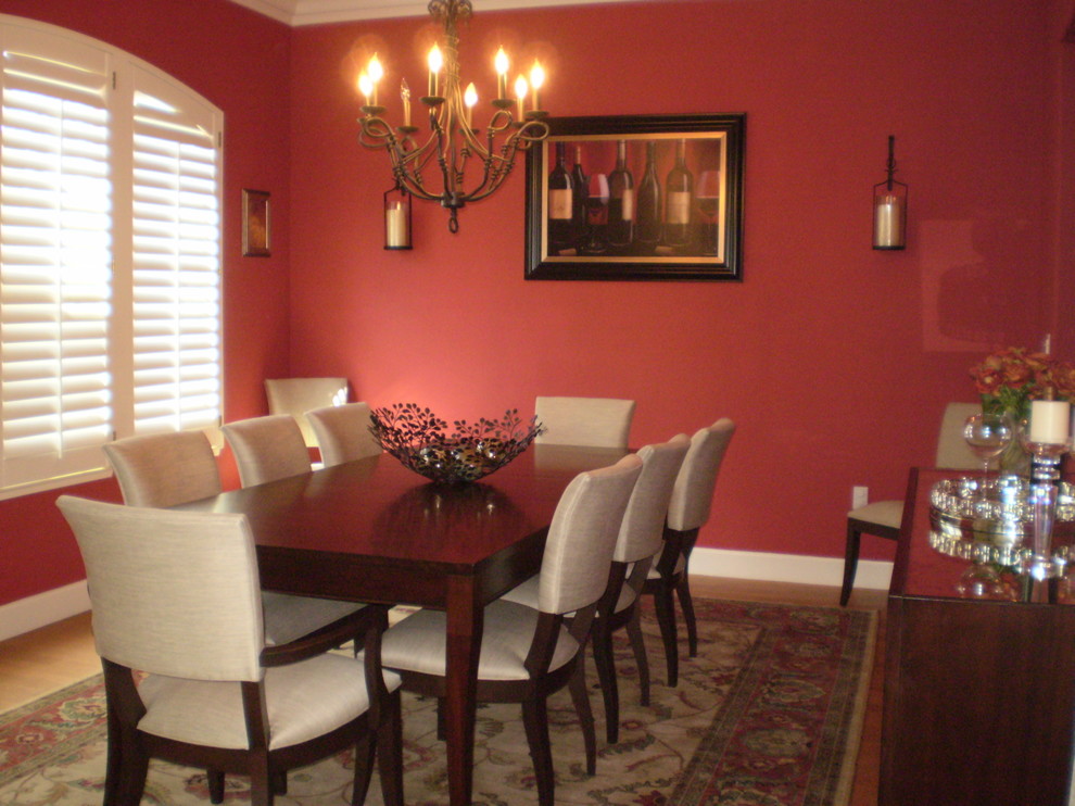 На фото: отдельная столовая среднего размера в классическом стиле с красными стенами, темным паркетным полом и коричневым полом