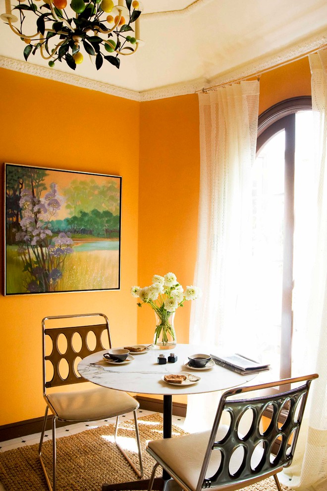 Immagine di una sala da pranzo eclettica con pareti gialle