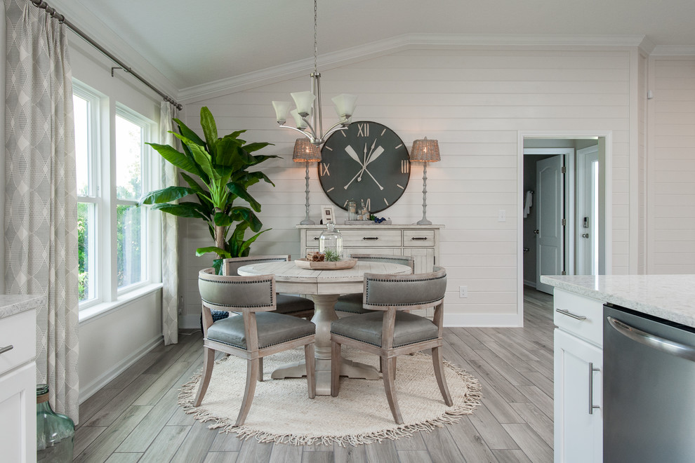 Aménagement d'une salle à manger ouverte sur la cuisine bord de mer de taille moyenne avec un mur blanc, un sol en carrelage de céramique et un sol beige.
