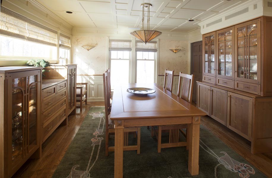 Cette image montre une grande salle à manger ouverte sur la cuisine craftsman avec un mur beige, un sol en bois brun et aucune cheminée.