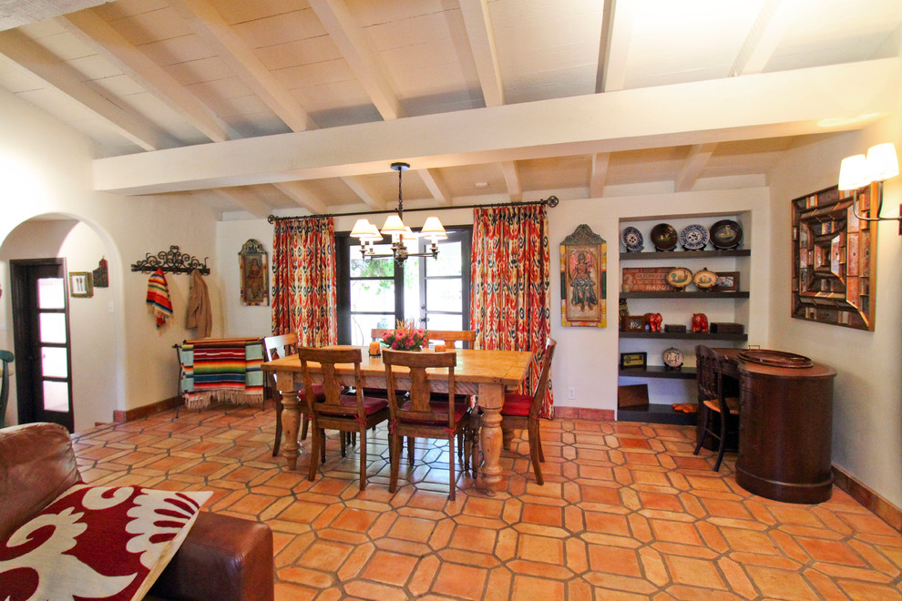 Immagine di una sala da pranzo stile americano con pareti bianche e pavimento in terracotta