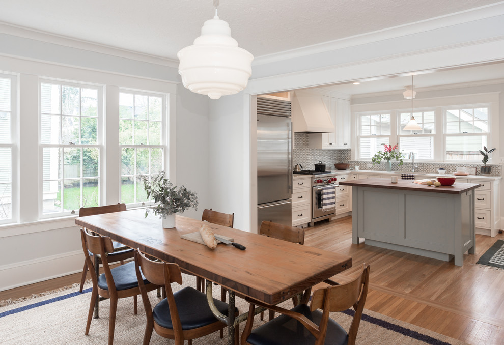 Ispirazione per una sala da pranzo aperta verso la cucina classica di medie dimensioni con pareti blu, parquet chiaro e pavimento marrone