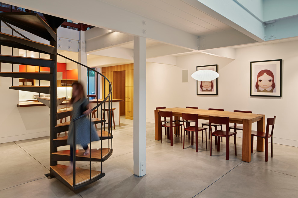 Esempio di una sala da pranzo aperta verso la cucina moderna con pareti bianche e pavimento in cemento