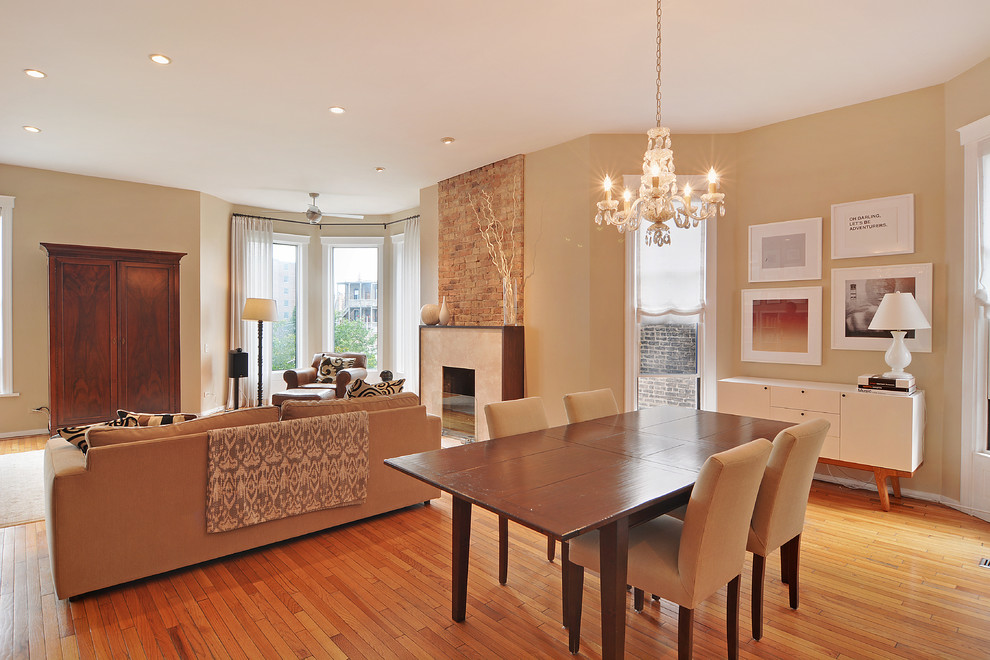 Contemporary open plan dining room in Chicago with beige walls, light hardwood flooring, a standard fireplace and a stone fireplace surround.