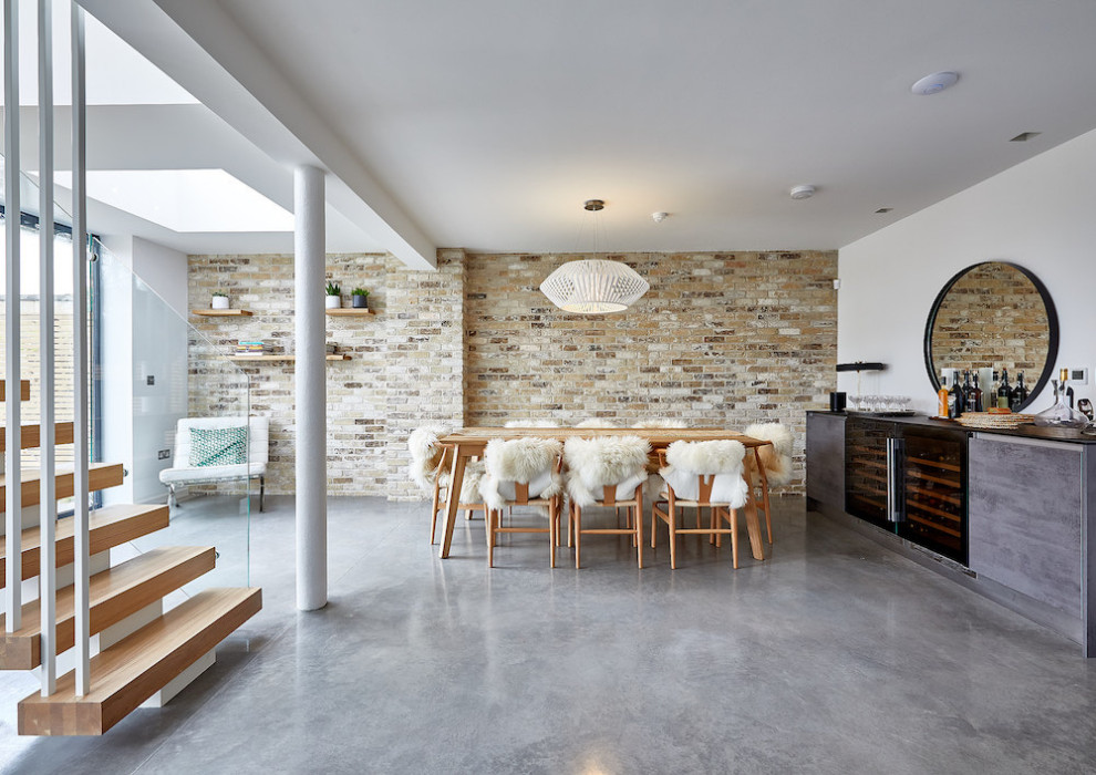 Idee per una sala da pranzo minimal con pareti bianche, pavimento in cemento, pavimento grigio e pareti in mattoni