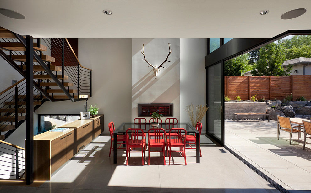 Стильный дизайн: столовая в современном стиле с белыми стенами и горизонтальным камином - последний тренд