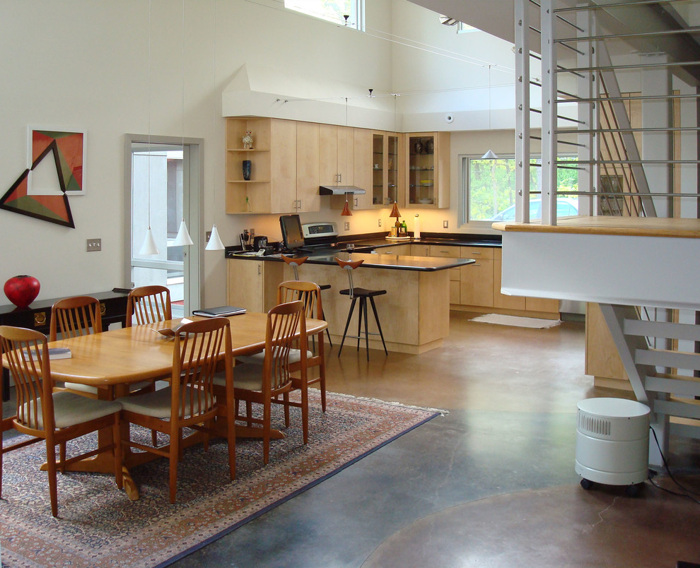 Aménagement d'une salle à manger ouverte sur la cuisine rétro avec sol en béton ciré.