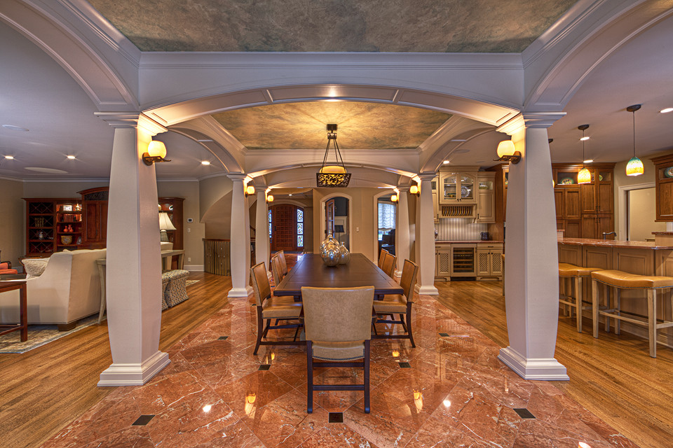 Immagine di una grande sala da pranzo aperta verso la cucina tradizionale con pareti beige e pavimento in marmo