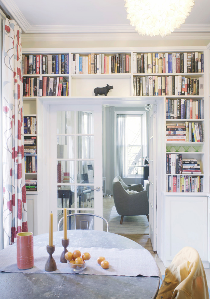 Immagine di una piccola sala da pranzo aperta verso la cucina minimal con pareti bianche, pavimento in legno massello medio, nessun camino e pavimento marrone