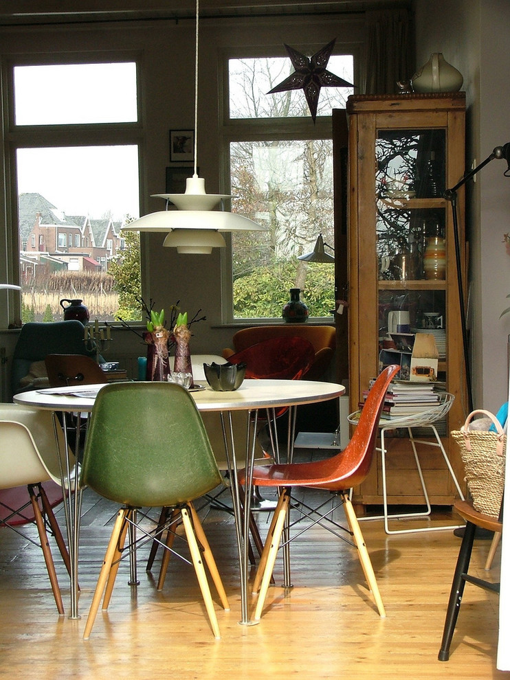 Photo of a retro dining room in Amsterdam with medium hardwood flooring.