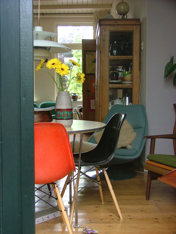 Réalisation d'une salle à manger vintage avec un mur blanc et un sol en bois brun.