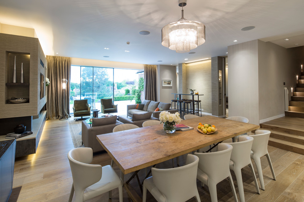 Large contemporary open plan dining room in London with beige walls and medium hardwood flooring.
