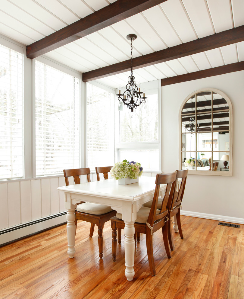 Foto di una piccola sala da pranzo aperta verso la cucina chic con pavimento in legno massello medio, pareti beige e pavimento marrone