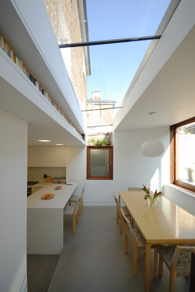This is an example of a contemporary kitchen/dining room in London with white walls and no fireplace.