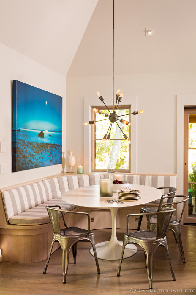 На фото: кухня-столовая среднего размера в современном стиле с белыми стенами и светлым паркетным полом с