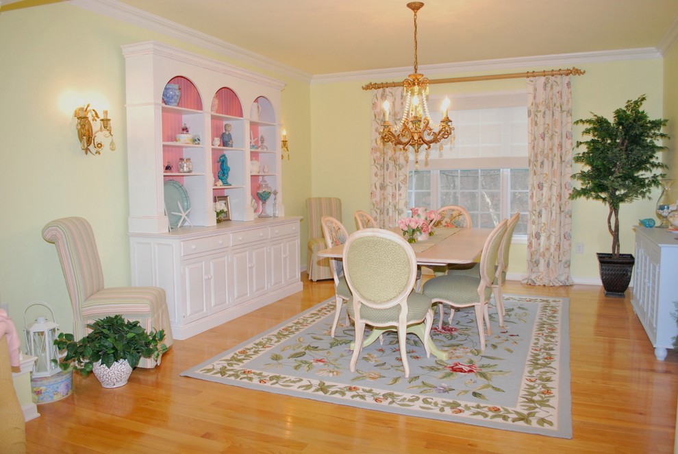 Medium sized classic enclosed dining room in New York with yellow walls and medium hardwood flooring.