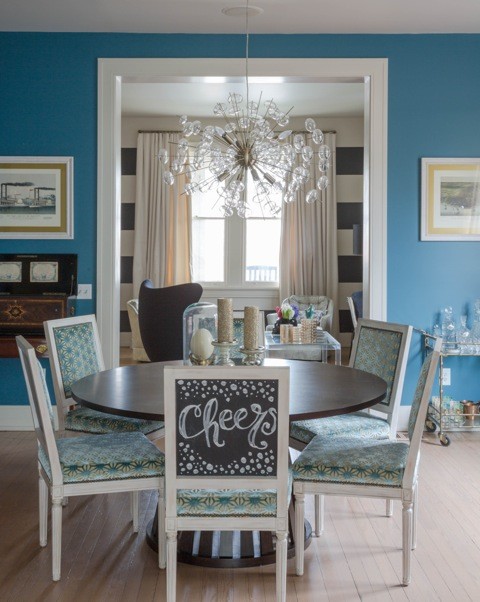 Immagine di una grande sala da pranzo minimal chiusa con pareti blu, parquet chiaro e nessun camino
