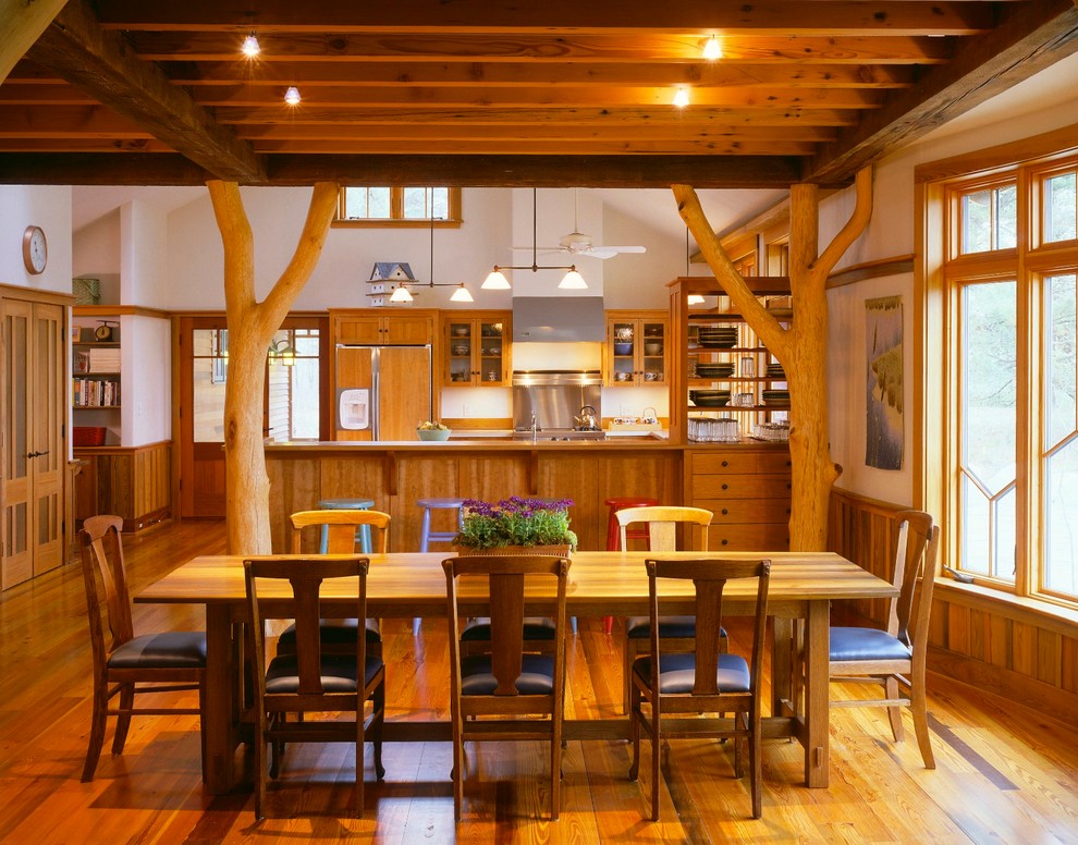 Immagine di una sala da pranzo aperta verso la cucina stile rurale con pareti bianche e parquet scuro