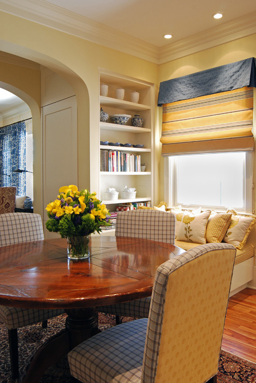 Esempio di una sala da pranzo eclettica con pareti gialle e pavimento in legno massello medio