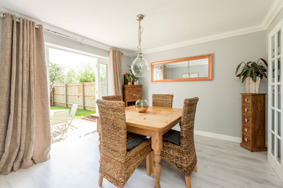Small rural enclosed dining room in Dorset with grey walls, laminate floors and grey floors.
