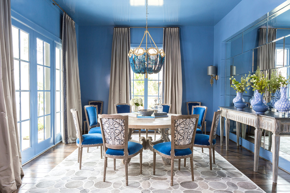 На фото: отдельная столовая в классическом стиле с синими стенами и темным паркетным полом с