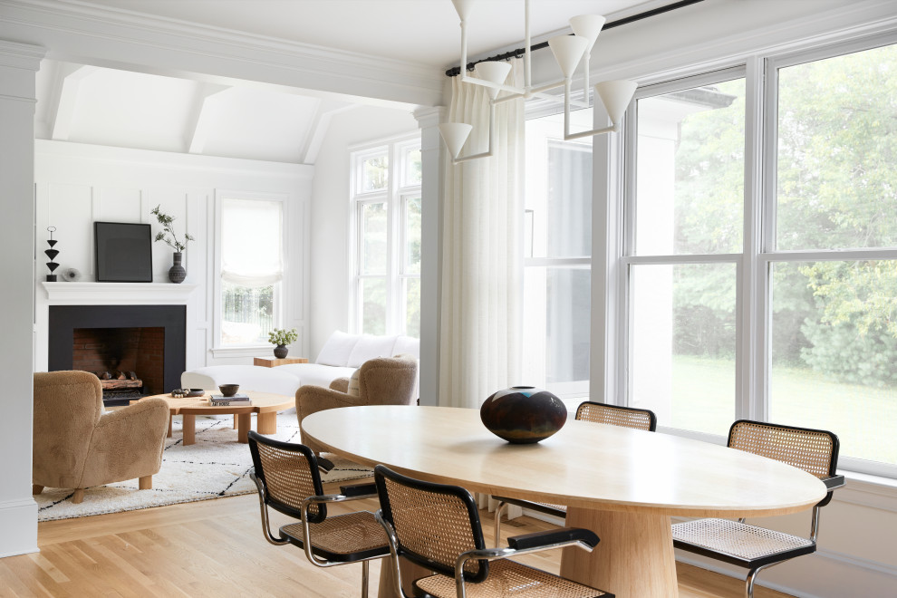 Foto di una sala da pranzo aperta verso il soggiorno nordica con pareti bianche, parquet chiaro e pavimento beige