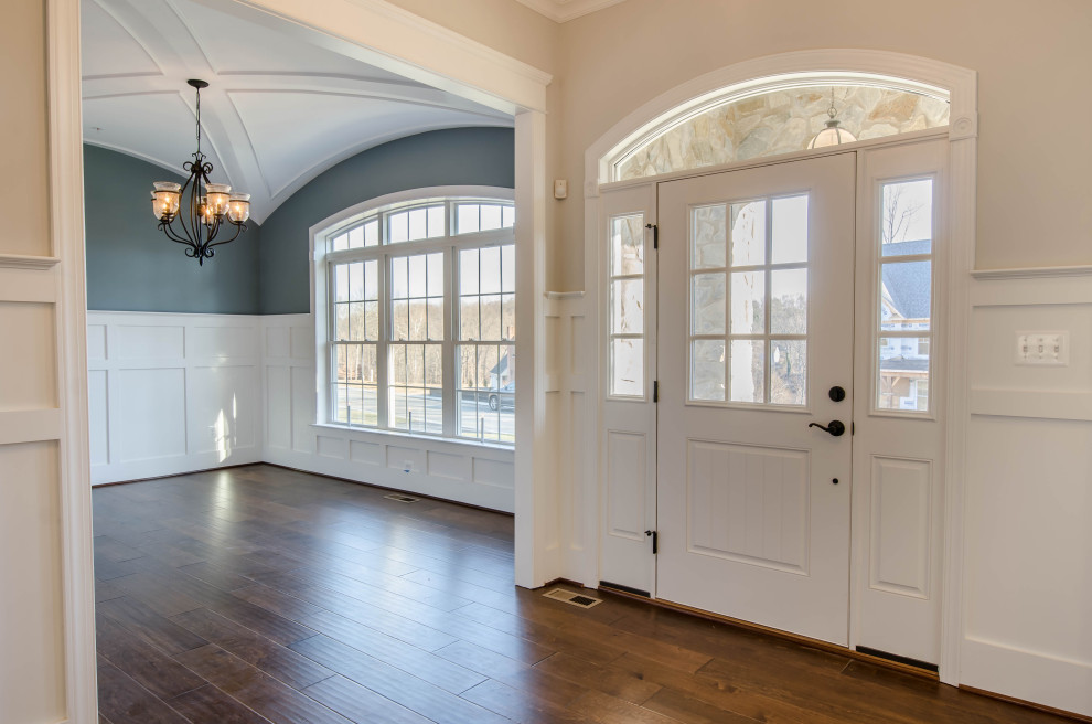 Foto di una sala da pranzo aperta verso la cucina tradizionale con pareti blu, pavimento in legno massello medio, pavimento marrone, soffitto a volta e boiserie