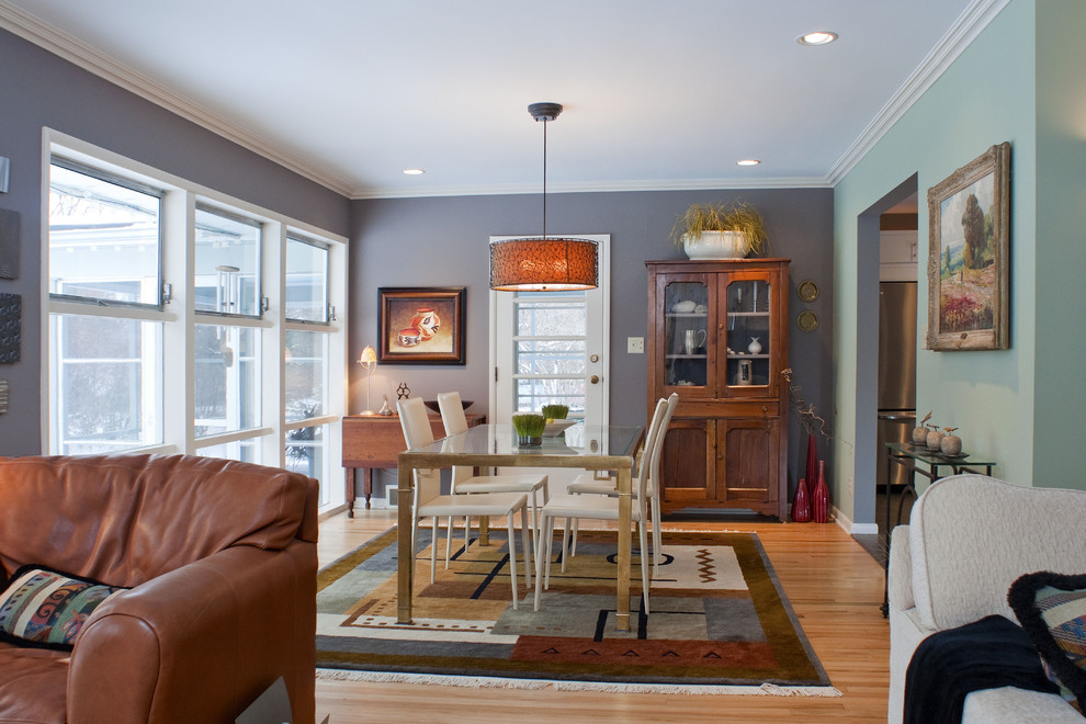 Immagine di una sala da pranzo aperta verso il soggiorno eclettica con pareti blu