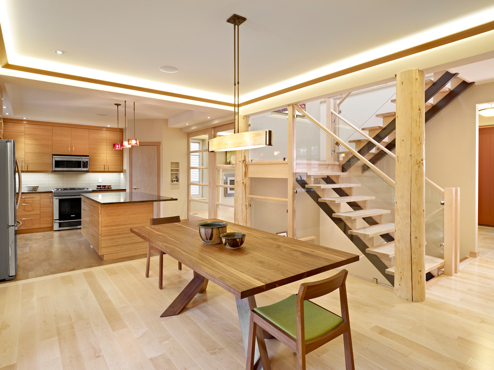 Idee per una sala da pranzo aperta verso la cucina design con pareti beige e parquet chiaro