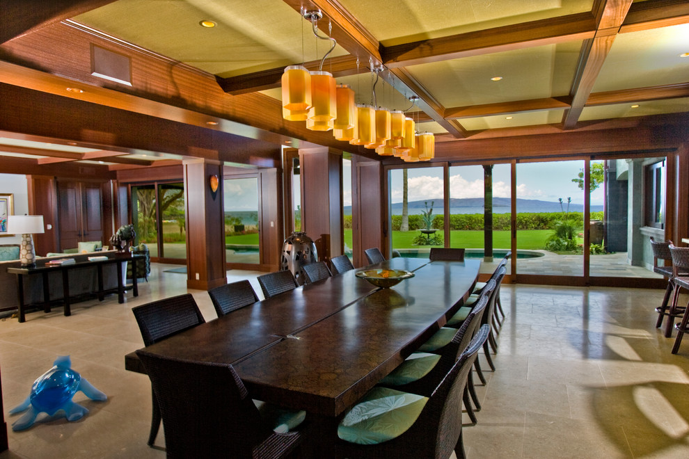 Immagine di un'ampia sala da pranzo aperta verso il soggiorno tropicale con pareti marroni e nessun camino