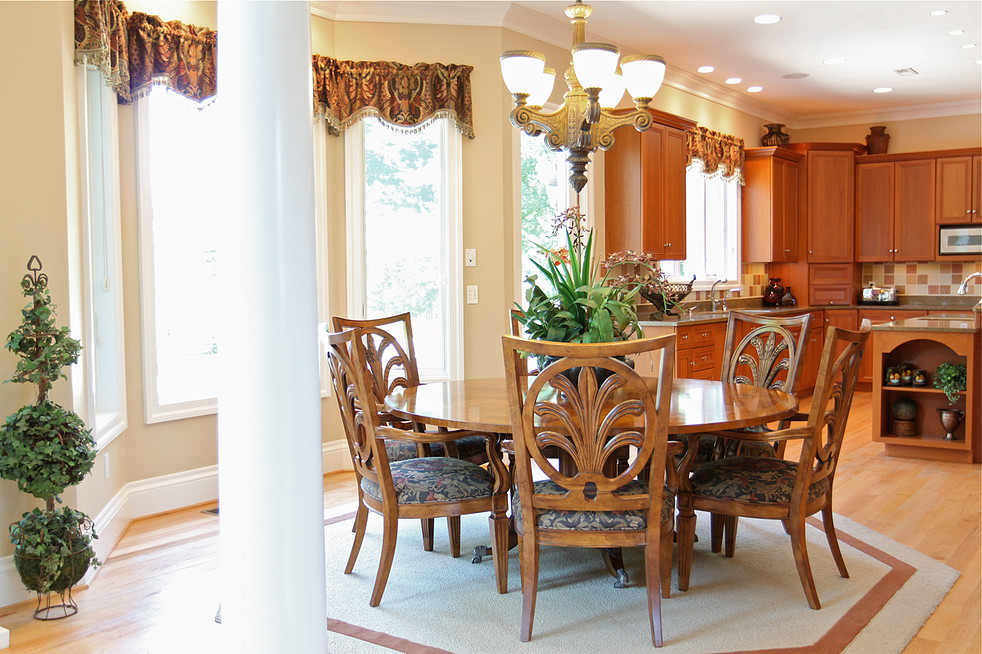 Foto di un'ampia sala da pranzo aperta verso la cucina classica con pareti beige, parquet chiaro, nessun camino e pavimento beige