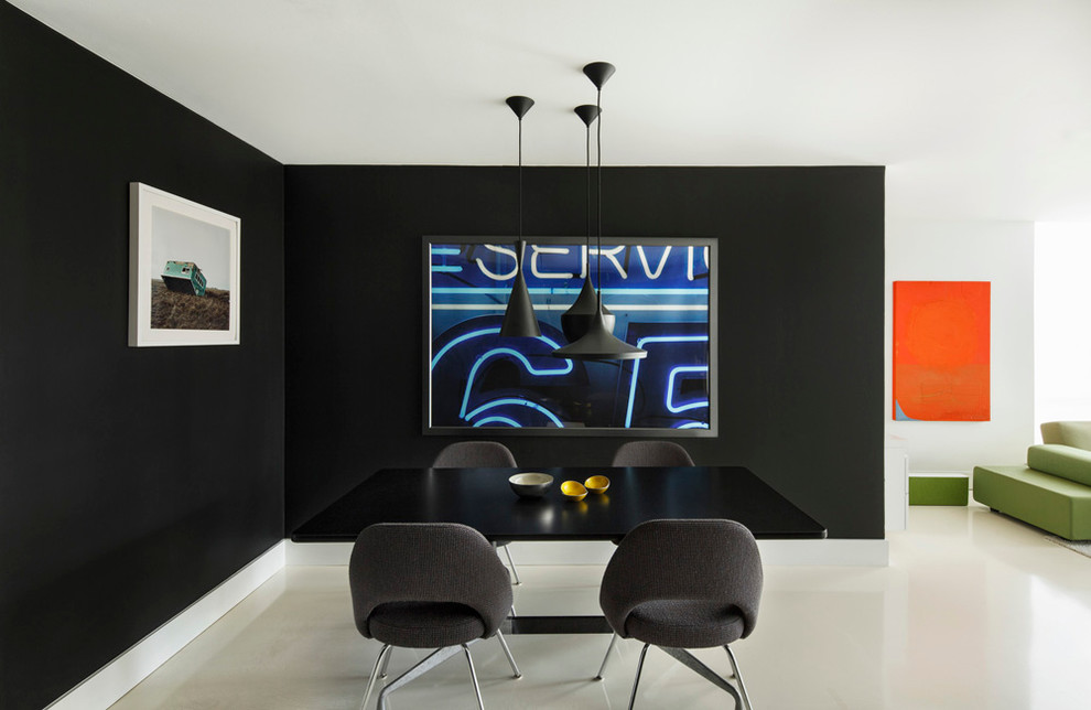 Exemple d'une salle à manger ouverte sur le salon tendance avec un mur noir et un sol blanc.