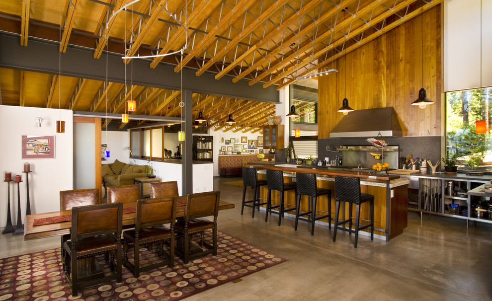 Immagine di una sala da pranzo aperta verso il soggiorno contemporanea con pavimento in cemento